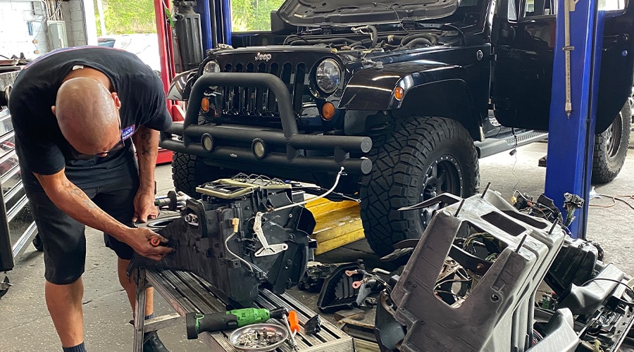 Maxi Auto Repair and Service’s technician working on a component of a Jeep. Concept image of “How to Keep Your Jeep in Top Shape” | Maxi Auto Repair and Service - Riverside in Jacksonville, FL.
