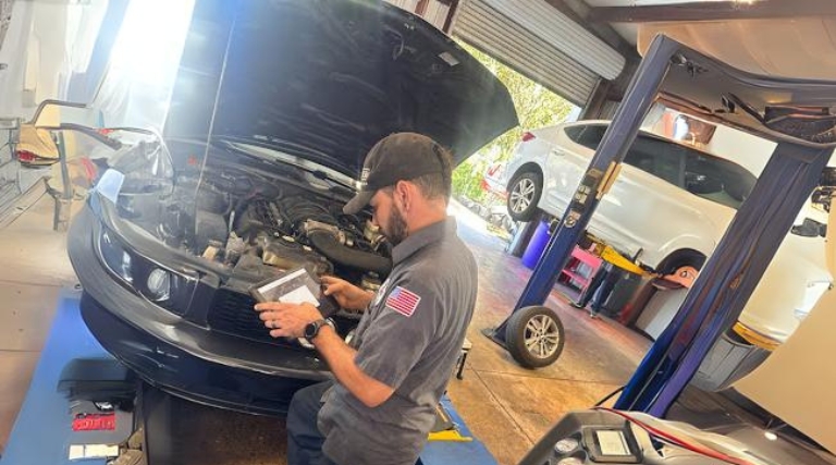 Professional vehicle diagnostics testing in Jacksonville, FL at Maxi Auto Repair Beach Blvd. Image of mechanic using diagnostic tool on vehicle in shop.