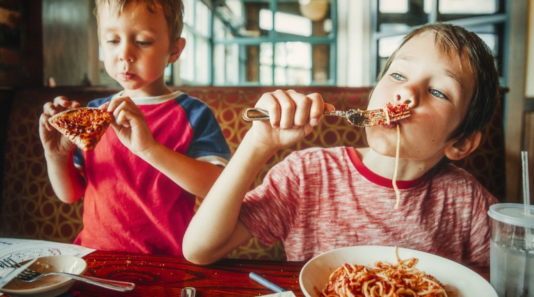 Best family friendly restaurants near Maxi Auto Repair in Jacksonville, FL. Image of two young boys eating spaghetti and pizza at a restaurant.