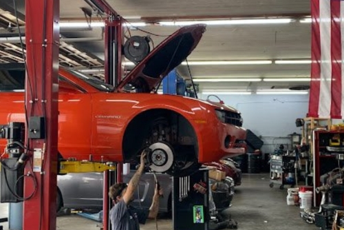 Brake Brake Repair Service near me in Jacksonville, FL at Maxi Auto Repair. Image of a white SUV being lifted for brake repair and maintenance