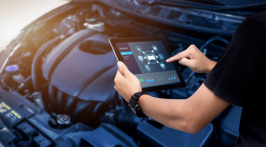 Computer diagnostics for Ford vehicles at Maxi Auto Repair in Jacksonville, FL. A technician uses a tablet to perform computer diagnostics on a Ford engine, showcasing advanced diagnostic services to ensure optimal performance and reliability.